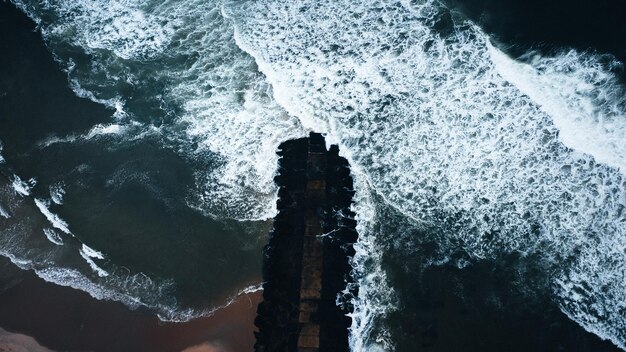 Toma aérea de hermosas olas del mar a la luz del día, perfecta para fondos de pantalla