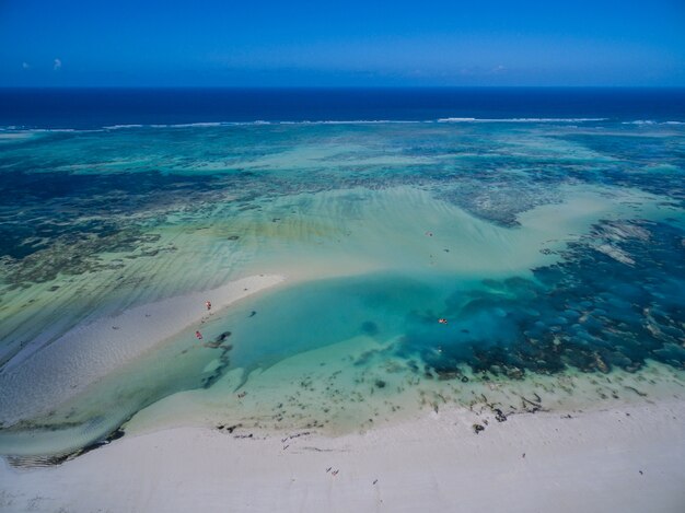 Toma aérea del hermoso océano azul tranquilo bajo el cielo azul capturado en Zanzíbar, África