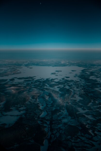 Toma aérea de un hermoso paisaje cubierto de nieve temprano en la mañana