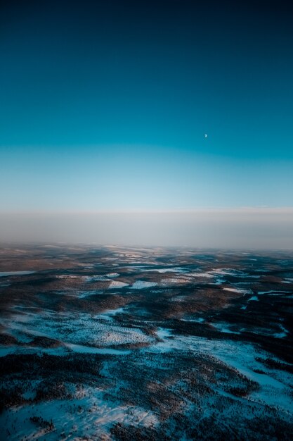 Toma aérea de un hermoso paisaje cubierto de nieve temprano en la mañana