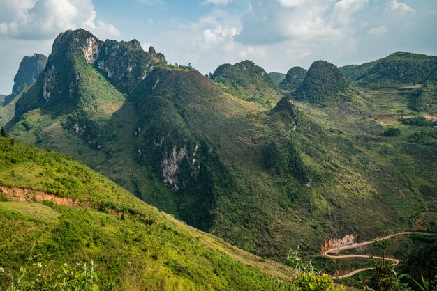 Toma aérea de un hermoso paisaje verde con altas montañas bajo el cielo nublado