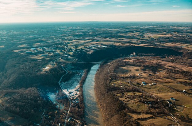 Toma aérea de hermosos caminos, ríos y campos con un soleado cielo azul