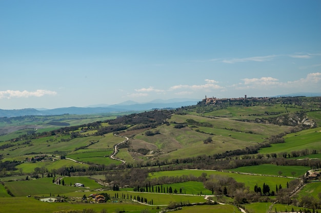Toma aérea de los impresionantes campos cubiertos de hierba bajo el hermoso cielo capturado en Italia