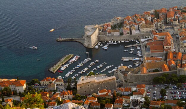 Toma aérea de la montaña Srđ en Dalmacia, Croacia, con sus lindas casas naranjas y calles concurridas