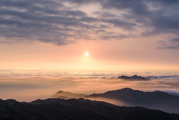 Toma aérea de montañas bajo un cielo nublado al atardecer