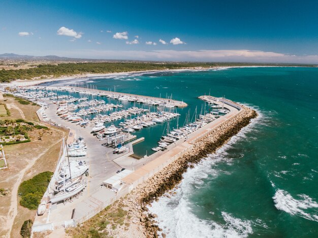 Toma aérea de un muelle con muchos barcos atracados en el agua