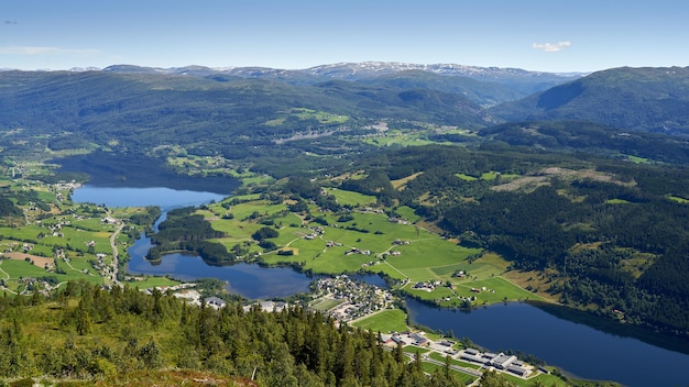 Toma aérea del municipio de Vossevangen rodeado de montañas cubiertas de vegetación en Noruega