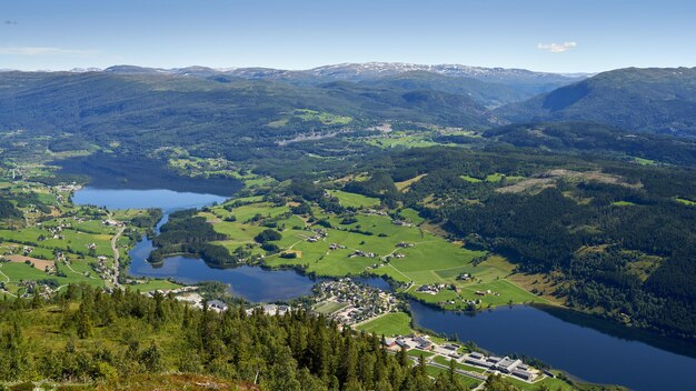 Toma aérea del municipio de Vossevangen rodeado de montañas cubiertas de vegetación en Noruega