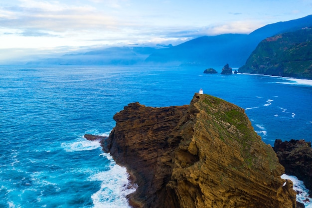 Toma aérea de olas del mar rompiendo en formaciones de piedra