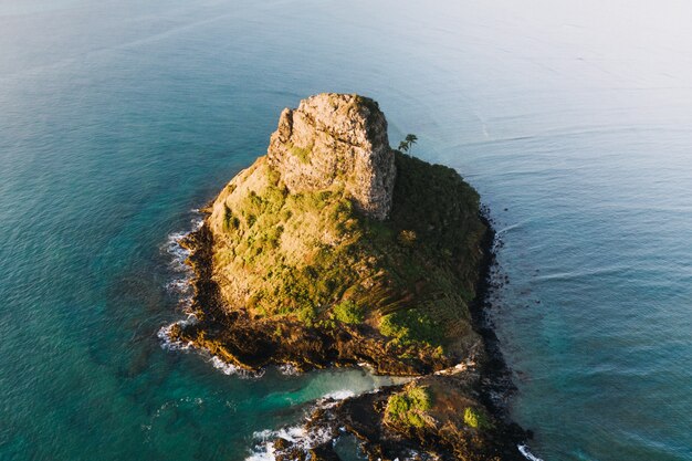 Toma aérea de una pequeña isla en el océano azul durante el día