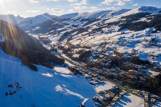 Toma aérea de un resort de snowboard en la nieve bajo la luz del sol