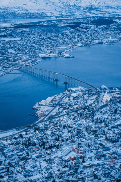 Toma aérea vertical de la hermosa ciudad de Tromso cubierta de nieve capturada en Noruega