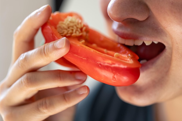 Foto gratuita toma detallada de una mujer muerde pimiento rojo