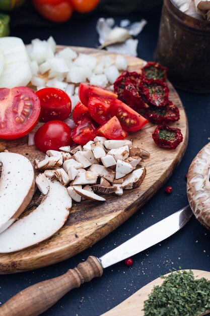 Toma de enfoque selectivo de tomates frescos y champiñones en rodajas con un fondo borroso