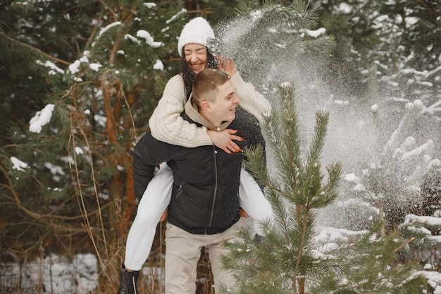Toma de estilo de vida de pareja caminando en el bosque nevado
