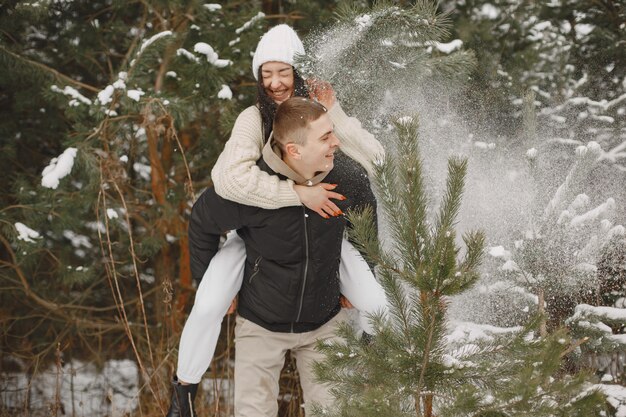 Toma de estilo de vida de pareja caminando en el bosque nevado