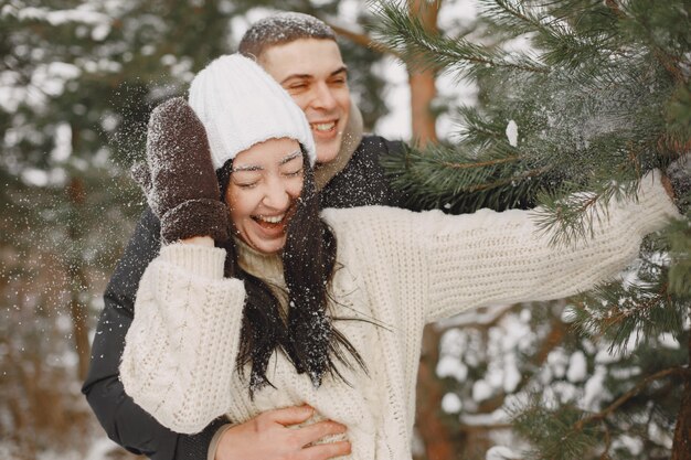 Toma de estilo de vida de pareja caminando en el bosque nevado