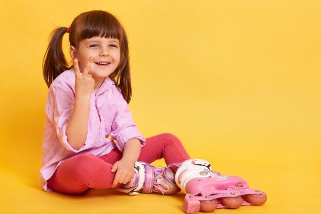 Toma interior de niña feliz sentada en el piso