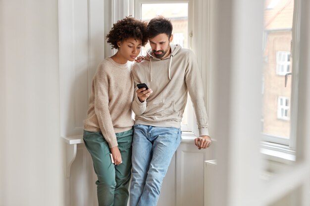 Toma en interiores de la novia y el novio de raza mixta ver video en línea a través de un teléfono celular