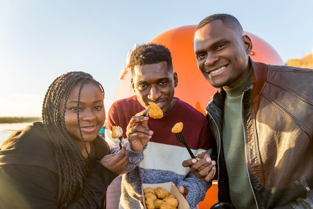 Toma media personas comiendo nuggets de pollo fuera de envases para llevar