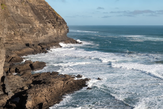 Toma de paisaje de una impresionante costa rocosa con acantilados y olas enojadas