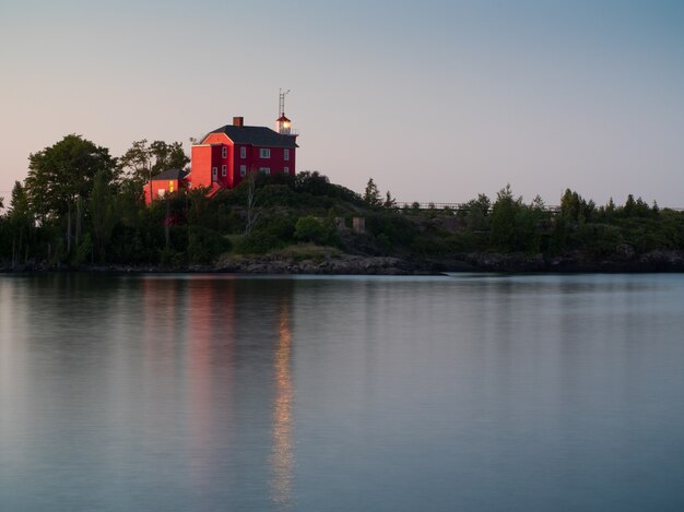 Toma de paisaje de un lago tranquilo con una casa roja en la orilla