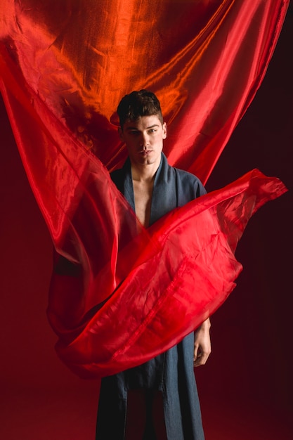 Foto gratuita toma de pan de tiro de hombre en traje con fondo rojo