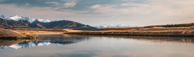 Toma panorámica del canal debajo del lago Pukaki en Twisel rodeado de montañas