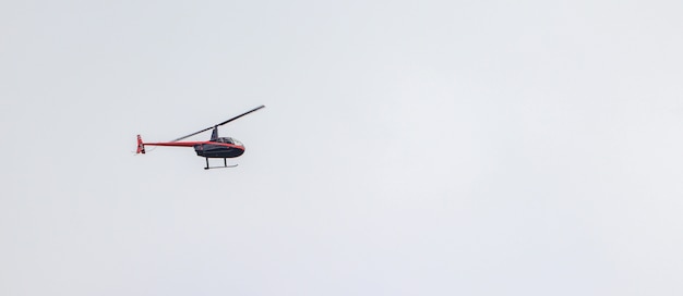 Foto gratuita toma panorámica de un helicóptero volando en un cielo nublado