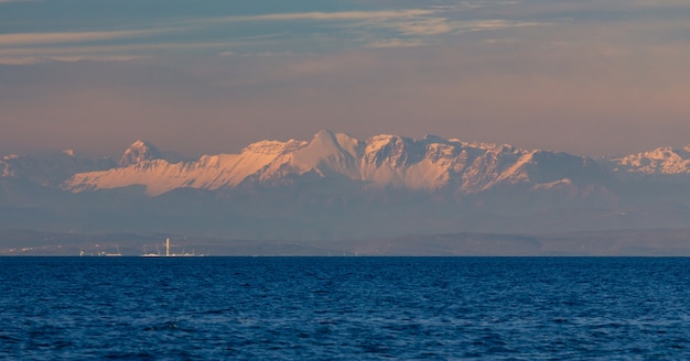 Toma panorámica del mar Adriático en Croacia durante la puesta de sol y los Alpes en el fondo