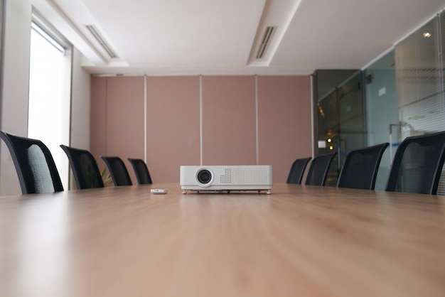 Toma panorámica de una oficina vacía con el proyector en medio de un escritorio de conferencia