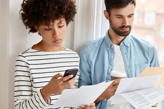 Toma recortada de colegas interraciales discutir opciones financieras estadísticas