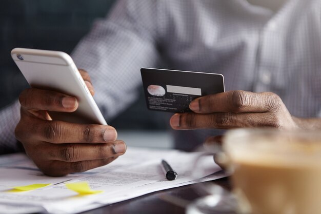 Toma recortada del empresario afroamericano pagando con tarjeta de crédito en línea