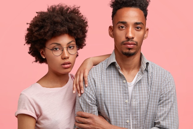 Toma recortada de serios socios negros de mujeres y hombres con expresiones pensativas