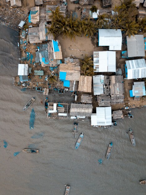 Toma vertical aérea de edificios cerca del mar con barcos