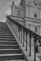 Foto gratuita toma vertical en ángulo bajo en escala de grises de las escaleras con una hermosa baranda que conduce al edificio histórico