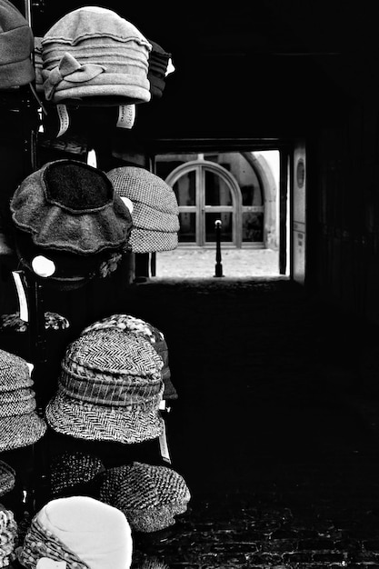 Foto gratuita toma vertical en escala de grises de sombreros colgados en una percha alta en la calle de la ciudad