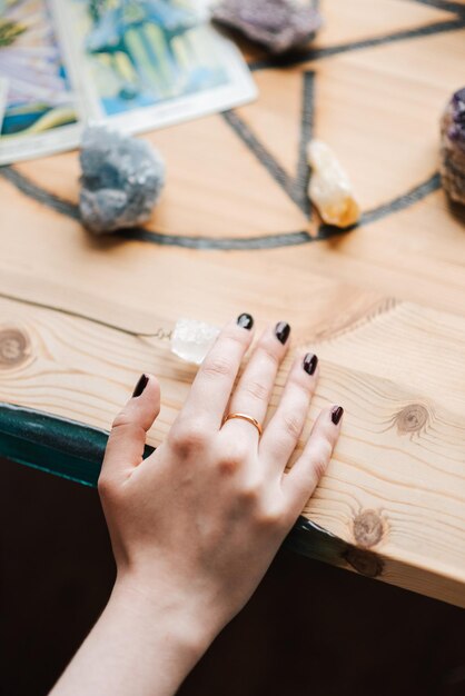 Toma vertical de la mano femenina caucásica sobre la mesa con piedras en un estudio de arte en el Reino Unido