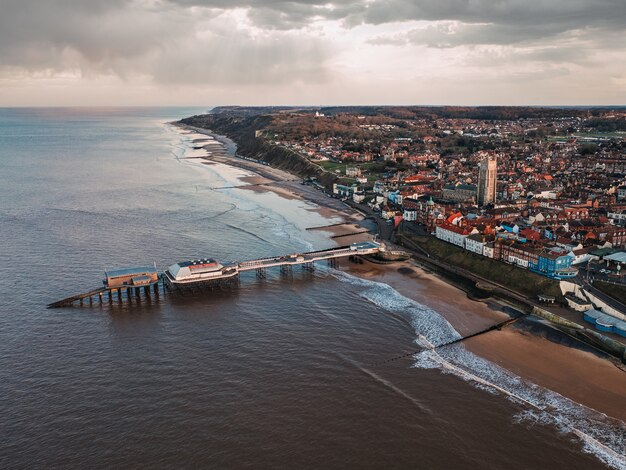 Toma a vista de pájaro de la ciudad, la playa pública y el muelle en un día sombrío