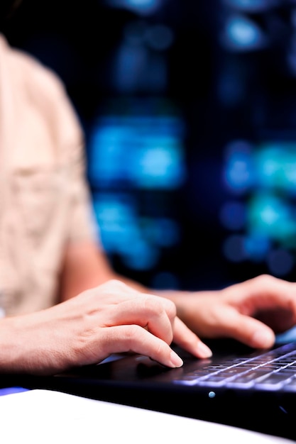 Tomada de cerca de un militar que se ocupa de fallas del sistema del centro de datos utilizando una computadora portátil para ordenar servidores con características de alta disponibilidad para minimizar el tiempo de inactividad y evitar accidentes