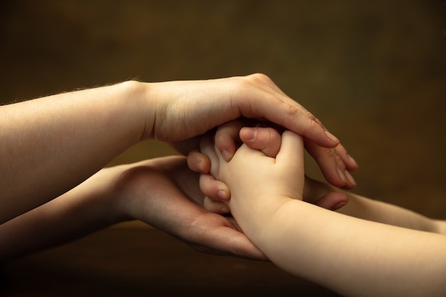 Tomados de la mano, aplaudiendo como amigos. Primer plano de las manos de mujeres y niños haciendo cosas diferentes juntos. Familia, hogar, educación, infancia, concepto de caridad. Madre e hijo o hija, riqueza.