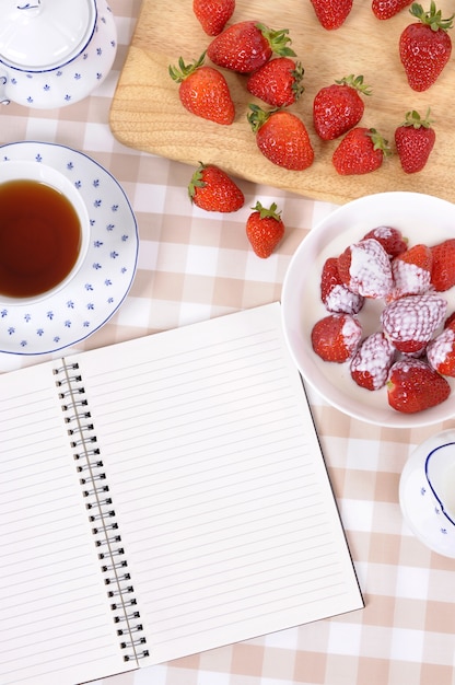 Foto gratuita tomando fresas con té