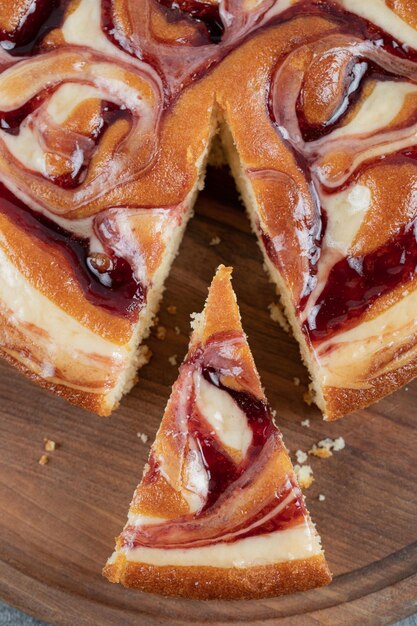 Tomando una rebanada de tarta de fresa sobre tabla de madera.