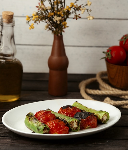 Tomate al horno y pimiento en una mesa de madera