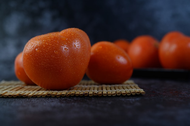 Tomate orgánico con gotas de agua en primer plano macro.