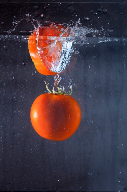 Tomate y rodaja de tomate en el agua