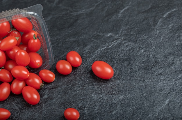 Tomate rojo pequeño para saludable, sobre fondo negro. Foto de alta calidad