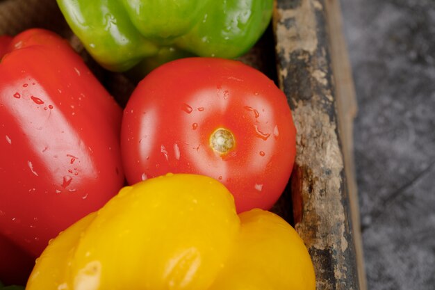 Tomate rojo con pimientos alrededor. Vista superior.