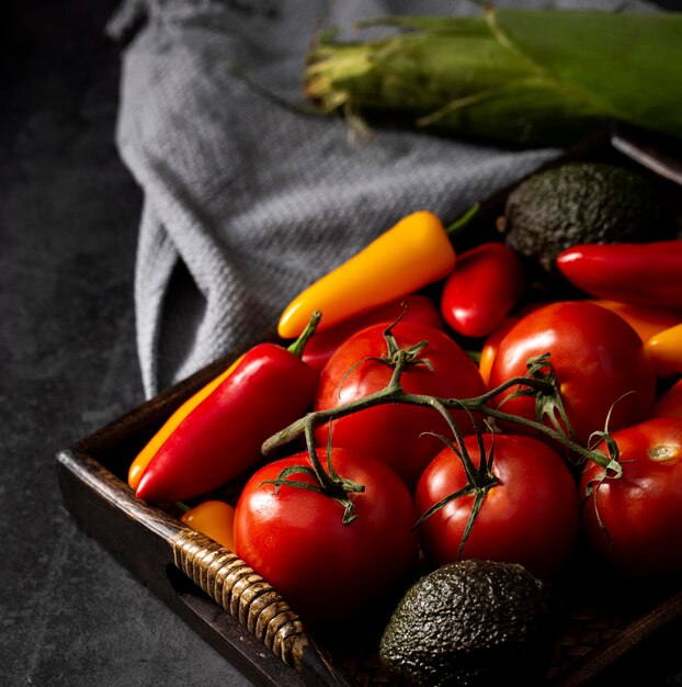 Tomates, aguacates y pimientos de alto ángulo en bandeja