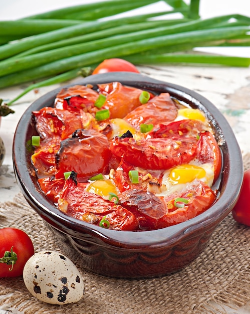 Tomates al horno con ajo y huevos decorados con cebolla verde